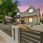 Two story California real estate house with gray walls, front yard, and driveway