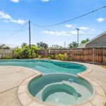 California real estate home backyard with pool, spa, fence, and plants