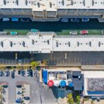 Aerial view of canal with boats, parking lot, buildings, and tanks