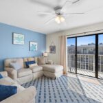 Living room with beige sofa, blue wall, nautical decor, and big window to balcony
