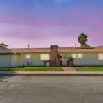California real estate house with light walls, chimney, and front yard